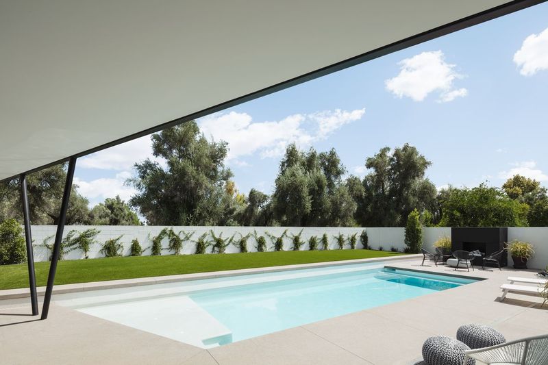 Contemporary desert residence at dusk with a pool and folding glass walls