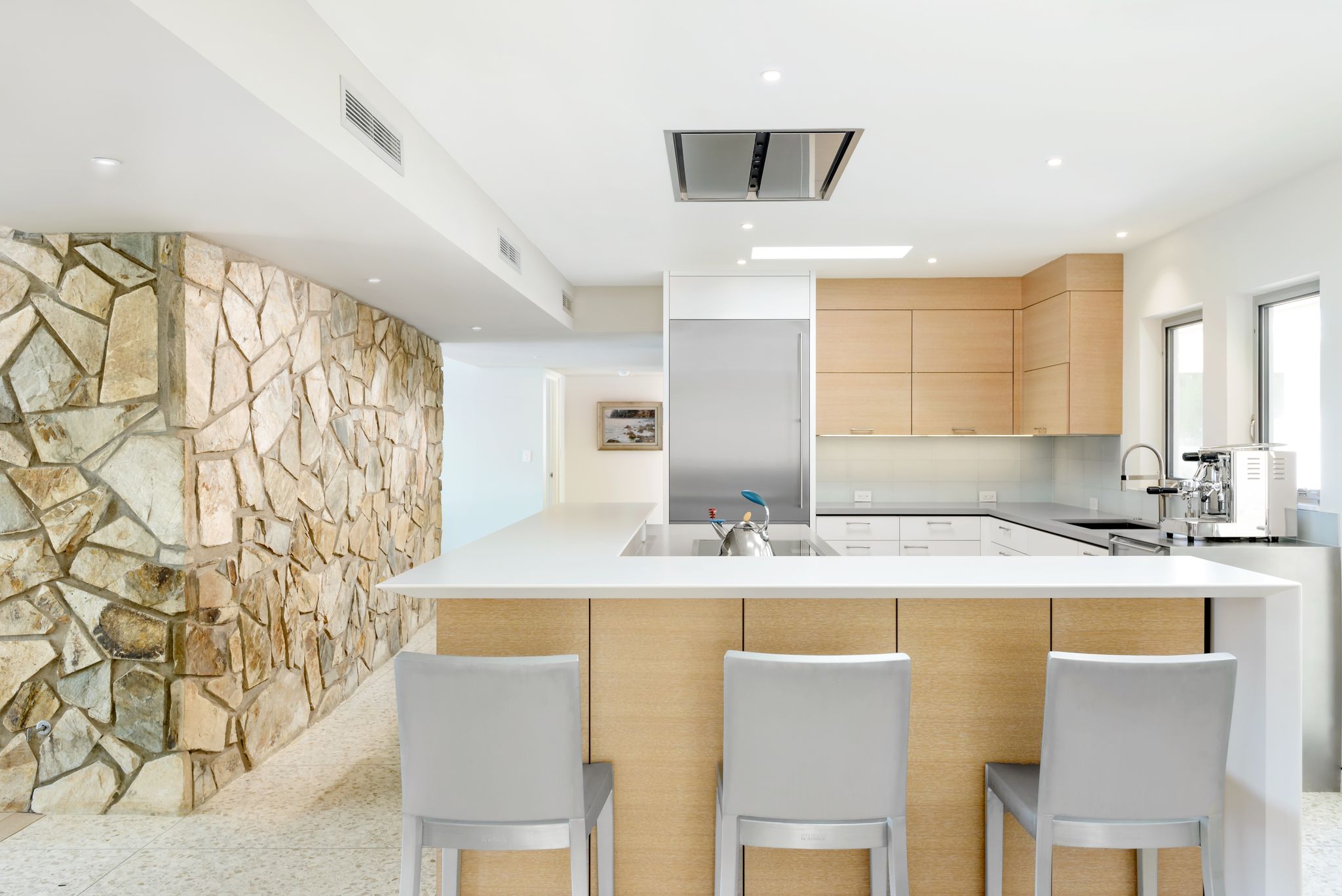 Remodeled kitchen with stone island, custom cabinetry and integrated appliances